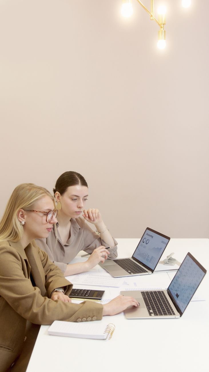 Two colleagues working through a task together at a laptop during a coaching session